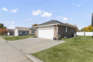 View of side of home with brick siding, concrete driveway, and a garage