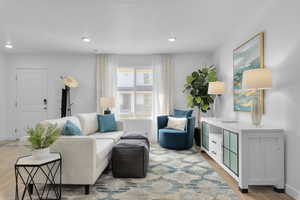 Living area featuring recessed lighting, baseboards, a textured ceiling, and light wood finished floors