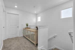Hall with recessed lighting, baseboards, carpet floors, and an upstairs landing