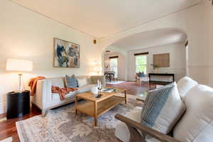 Living room featuring arched walkways and wood finished floors
