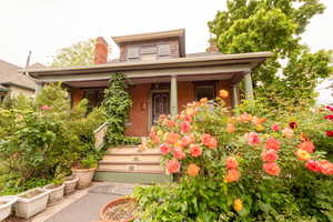 Doorway to property with brick siding and covered porch