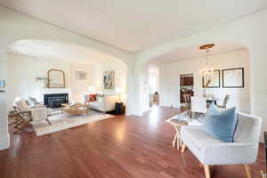 View of Living room from adjacent sitting room, arched doorways, and laminate wood finished floors. Natural lights flood these rooms