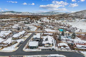 Snowy aerial view featuring a mountain view and a residential view