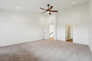 Unfurnished bedroom with high vaulted ceiling, recessed lighting, baseboards, and carpet