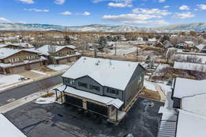 Snowy aerial view with a mountain view and a residential view