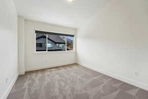 Spare room featuring carpet, visible vents, and baseboards
