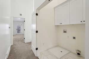 Washroom with visible vents, hookup for an electric dryer, baseboards, cabinet space, and washer hookup