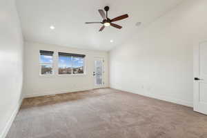 Spare room featuring baseboards, carpet floors, ceiling fan, and vaulted ceiling