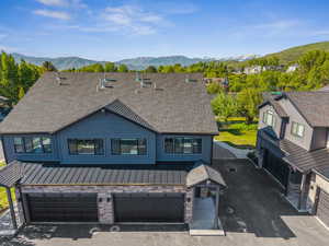 View of front facade featuring a standing seam roof, an attached garage, a mountain view, metal roof, and board and batten siding