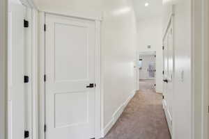 Corridor featuring recessed lighting, visible vents, baseboards, and light colored carpet
