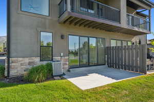 Back of property with a balcony, a patio area, and stucco siding