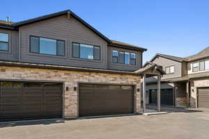 View of property featuring stone siding and an attached garage