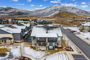 Snowy aerial view featuring a mountain view and a residential view