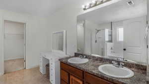 Bathroom with visible vents, a shower stall, a garden tub, and a sink