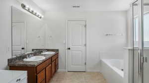 Full bathroom featuring a sink, visible vents, a garden tub, and double vanity