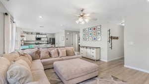 Living area featuring recessed lighting, baseboards, light wood-style floors, and ceiling fan