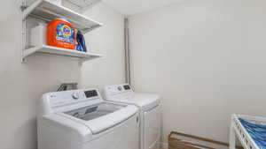 Laundry area with laundry area, baseboards, and separate washer and dryer