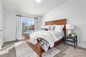 Bedroom with vaulted ceiling, access to exterior, baseboards, and carpet floors