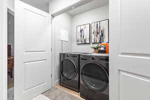 Clothes washing area featuring washer and dryer and laundry area