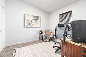Home office with baseboards, carpet floors, and vaulted ceiling