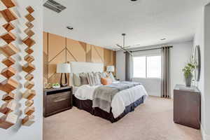 Bedroom featuring visible vents, light colored carpet, a textured ceiling, and baseboards