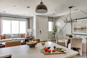 Living area with a healthy amount of sunlight, visible vents, and a textured ceiling