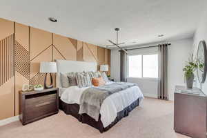 Bedroom featuring baseboards, light carpet, and a textured ceiling