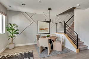Dining area featuring stairway, baseboards, visible vents, and wood finished floors