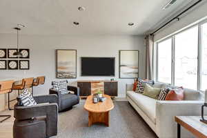 Living area featuring visible vents, recessed lighting, a textured ceiling, and baseboards