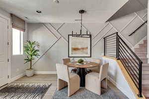 Dining room featuring visible vents, baseboards, wood finished floors, and stairs