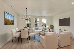 Living area featuring a chandelier, light wood-style floors, baseboards, and recessed lighting