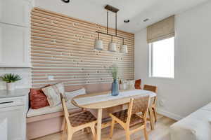 Dining room featuring light wood-style floors, visible vents, breakfast area, and baseboards