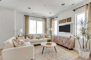 Living area featuring light wood-type flooring, visible vents, and recessed lighting