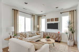 Living area featuring recessed lighting, visible vents, baseboards, and light wood finished floors
