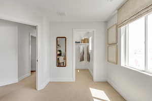 Spare room with baseboards, light carpet, and visible vents