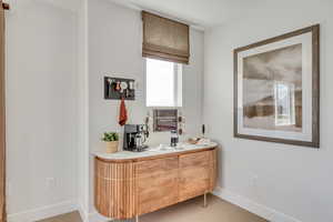 Bar featuring baseboards and light carpet