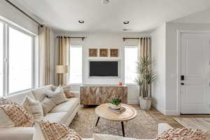 Living room featuring plenty of natural light, recessed lighting, baseboards, and wood finished floors