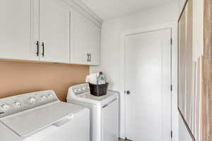 Laundry area with cabinet space and washer and clothes dryer