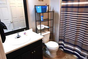 Full bath with tile patterned flooring, a shower with shower curtain, toilet, and vanity