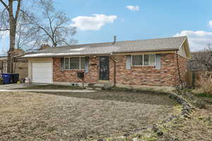Ranch-style house featuring brick siding, an attached garage, concrete driveway, and a shingled roof