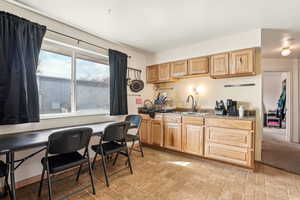 Kitchen featuring light brown cabinets, brick patterned floor, and a sink
