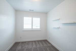 Spare room with carpet, visible vents, and baseboards