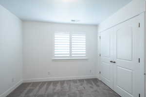 Unfurnished bedroom featuring carpet, visible vents, a closet, and baseboards