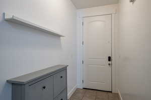 Entryway featuring baseboards and light tile patterned flooring