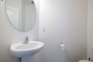 Half bathroom with visible vents, toilet, and a sink