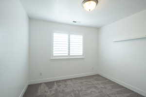 Spare room with visible vents, baseboards, and carpet