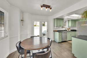 Dining room featuring crown molding, baseboards, french doors, wood finished floors, and a textured ceiling