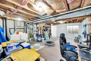 Unfinished below grade area with washing machine and clothes dryer and strapped water heater