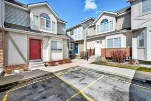 View of front of home with uncovered parking, brick siding, and stucco siding