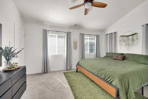 Bedroom with visible vents, baseboards, lofted ceiling, light carpet, and a textured ceiling